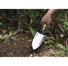 Grădinar plantând cu o plantatoare în grădină.