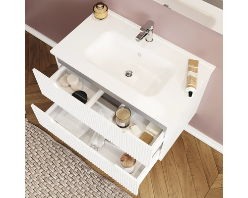 Dulap de lavoar alb cu două sertare deschise și diverse articole de baie