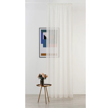 Cameră decorativă cu perdea albă transparentă, măsuță laterală cu flori și o imagine înrămată.