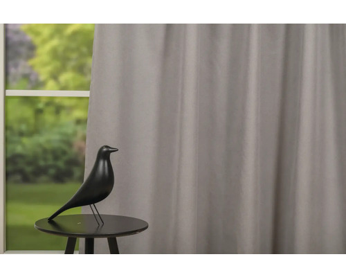 Decoratiune cu pasăre pe o masă în fața unei ferestre cu perdea