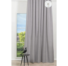 Vedere a unei perdele gri în fața unei ferestre cu o figurină decorativă pe o masă