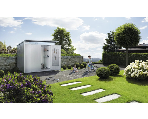 Scenă de grădină cu magazie metalică pentru unelte, copii care se joacă și unelte de grădină