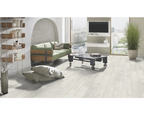 Living luminos cu rafturi, canapea, măsuță de cafea și podea deschisă din lemn.