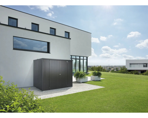 Cabină de grădină metalică lângă o casă rezidențială modernă cu gazon
