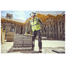 Muncitor în construcții cu dispozitiv de ridicat pietre pe un șantier.