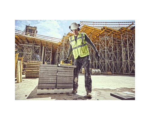 Muncitor în construcții cu dispozitiv de ridicat pietre pe un șantier.