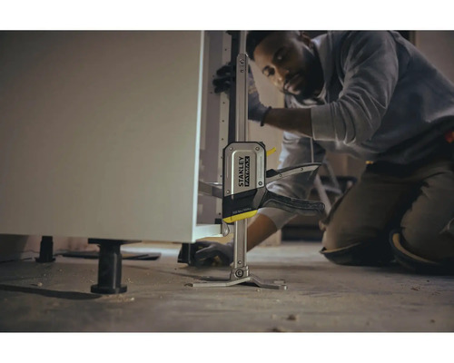 Un meșter folosește un elevator pentru dulapuri de bucătărie Stanley Fatmax pentru a instala un dulap de bucătărie.