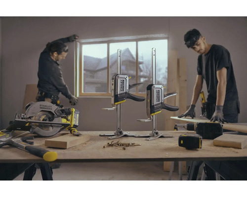 Scenă dintr-un atelier cu unelte și doi meșteri care lucrează la o fereastră.