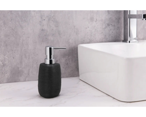 Dozator de săpun negru lângă o chiuvetă albă