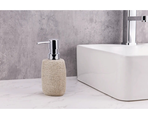 Dozator de săpun cu aspect de piatră, cu pompă cromată, lângă o chiuvetă