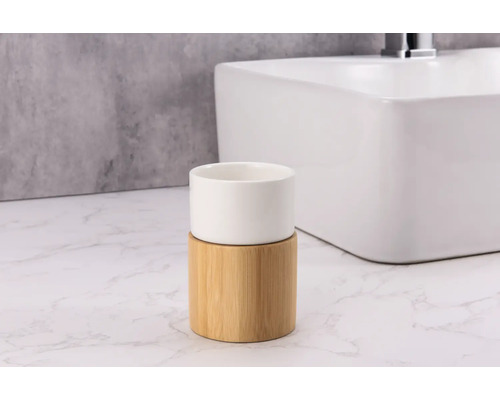 Pahar pentru periuțe de dinți din bambus și ceramică în fața unei chiuvete