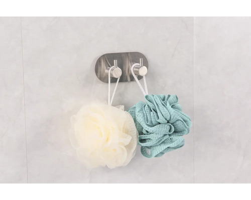 Două bureți de duș atârnă pe un cârlig pentru depozitare în baie.