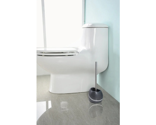 Toaletă albă cu piedestal și perie de toaletă în baie