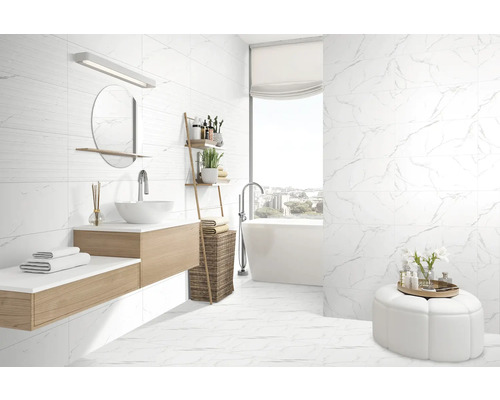 Baie modernă cu gresie de marmură albă, lavoar și cadă independentă.