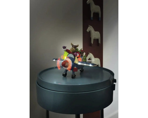 Avion decorativ cu figurină de elan și iluminare pe o măsuță laterală