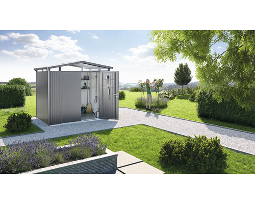 Scenă de grădină cu magazie de scule, gazon și femeie grădinărit.