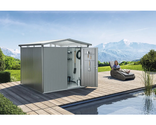 Cabină de grădină metalică cu ușa deschisă și unelte pe interiorul ușii pe o terasă din lemn lângă o piscină