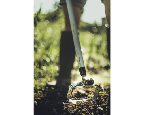 Lucrarea solului cu o sapă oscilantă în grădină.