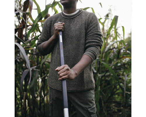 Bărbat cu o unealtă de grădină Fiskars într-un câmp