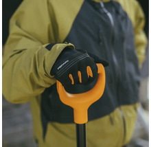 O persoană ține o lopată cu mănuși marca Fiskars.