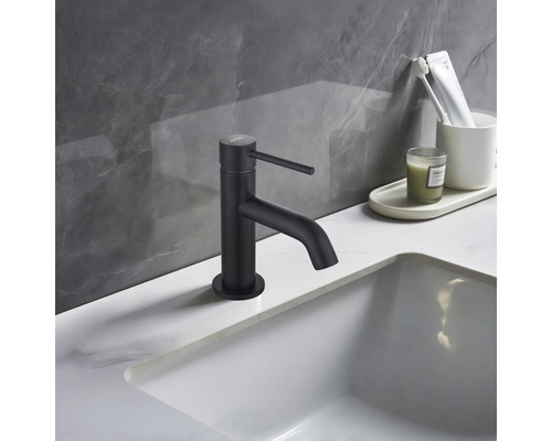 Baterie neagră de lavoar pe o chiuvetă în baie.