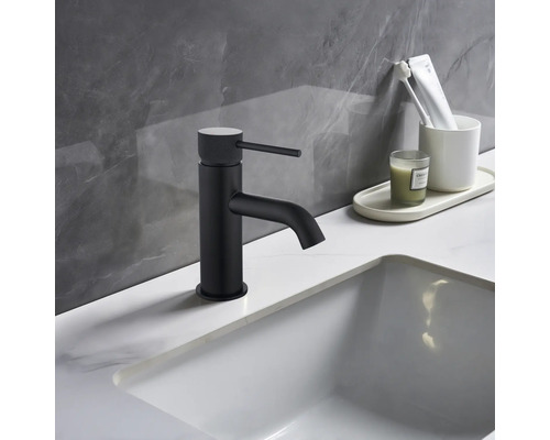 Baterie de lavoar neagră lângă chiuvetă albă și articole de baie