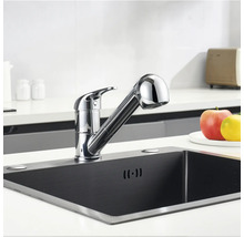 Baterie de bucătărie cu duș extractibil într-o chiuvetă întunecată.