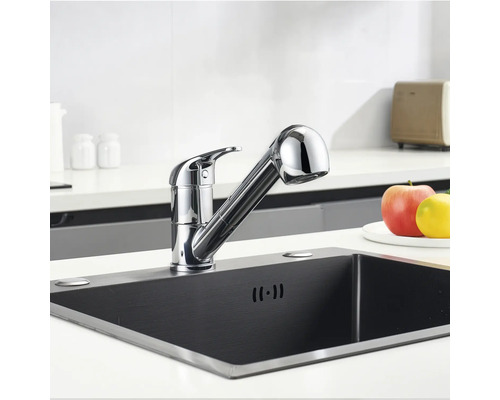 Baterie de bucătărie cu duș extractibil într-o chiuvetă întunecată.