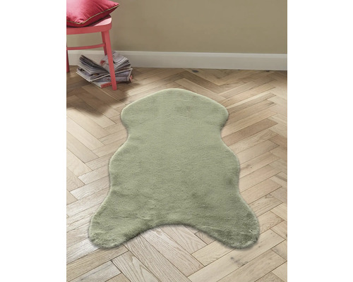 Blană decorativă pe podea de lemn cu scaun și reviste în fundal