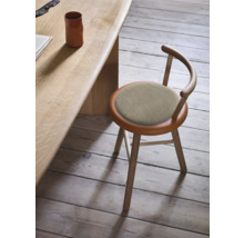 Scaun din lemn cu șezut tapițat lângă o masă din lemn