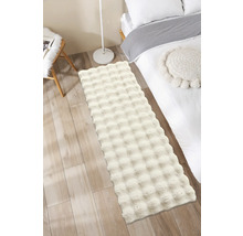 Covor pufos în dormitor lângă un pat și o lampă.