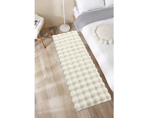 Covor pufos în dormitor lângă un pat și o lampă.