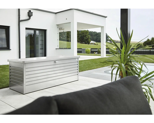 Ladă depozitare grădină Biohort 200 metal 201x79x83 cm 1050 l argintiu metalizat Scenă de grădină cu o cutie de depozitare metalică pe o terasă