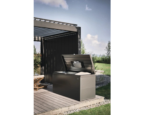 Cutie de depozitare deschisă pe o terasă de lemn în grădină.