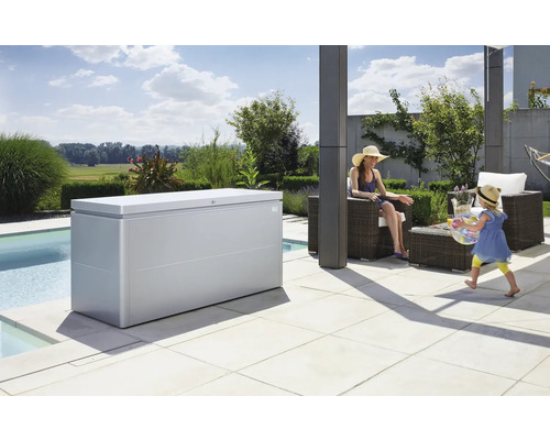 Ladă depozitare grădină Biohort LoungeBox 200 metal 200x84x88,5 cm 1400 l argintiu metalizat Scenă în aer liber cu o cutie de depozitare gri, mobilier de grădină și persoane care se joacă