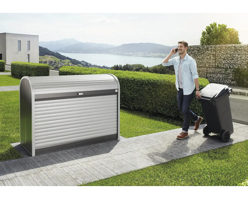 Mască tomberon Biohort StoreMax 160 metal 163x78x120 cm argintiu/gri închis Cutie metalică pentru pubele cu oblon rulant în grădină, bărbat vorbește la telefon și trage pubela