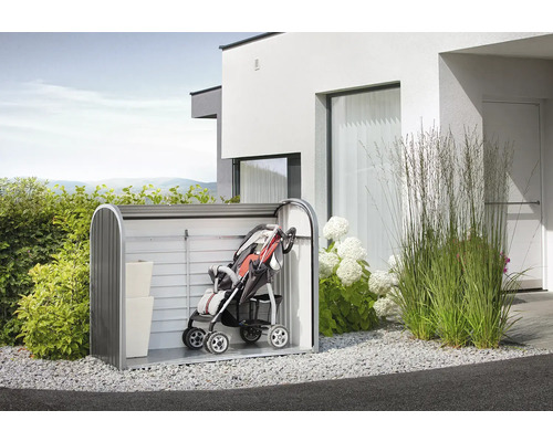 Scenă de grădină cu magazie de scule cu cărucior și cutii de depozitare în fața unei case