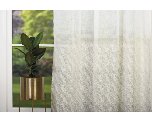 Cortină decorativă cu motiv de plante și plantă de interior în ghiveci auriu în fața unei ferestre