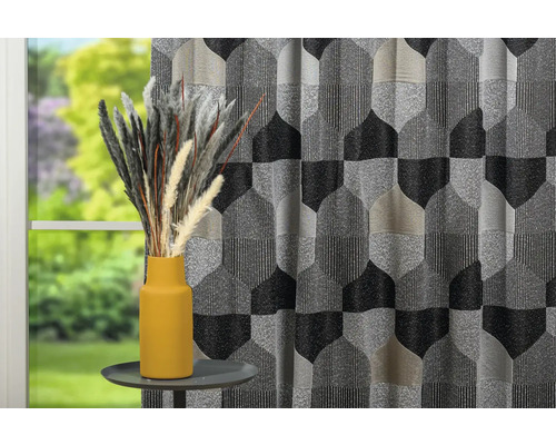 Cortină decorativă cu model geometric și vază cu iarbă ornamentală pe o masă