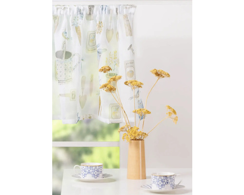 Perdele cu motive de grădină, vază cu flori uscate și cești pe o masă