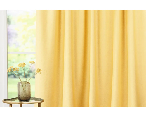Cortină galbenă lângă o fereastră și flori într-o vază pe o măsuță laterală.