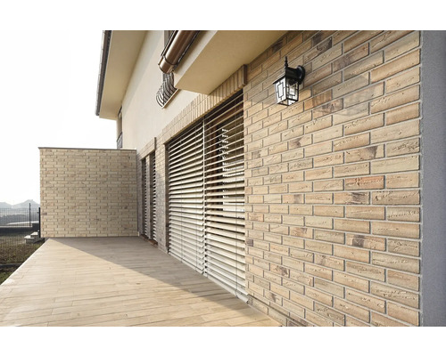 Fațadă de casă cu zidărie, jaluzele și iluminat exterior