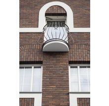Fațada unei clădiri cu zidărie de cărămidă, ferestre și balcon