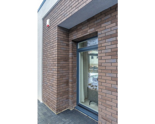 Perete de casă cu cărămizi decorative și fereastră