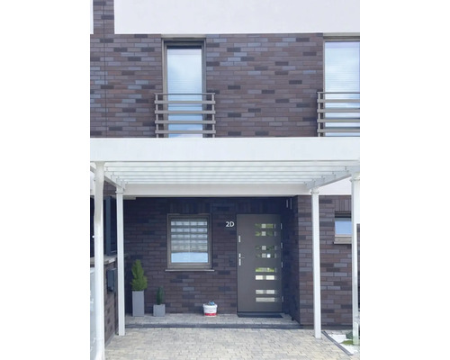 Fațadă de casă cu carport, ușă de intrare și ferestre într-un design modern.