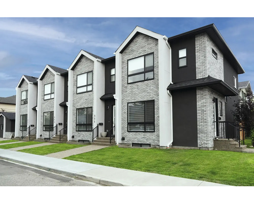 Case înșiruite cu fațade din cărămidă și tencuială și peluze