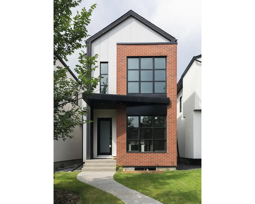 Vedere a unei case moderne cu două etaje, cu fațadă din cărămidă și tencuială