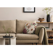 Scenă de living cu canapea bej, pernă decorativă florală și măsuță laterală