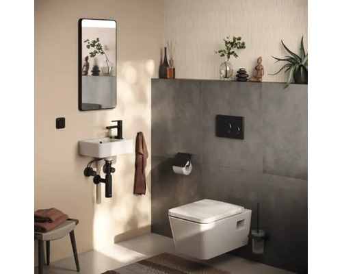 Baie modernă cu toaletă, chiuvetă, oglindă și decorațiuni.