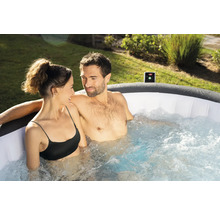 Un cuplu se relaxează într-un jacuzzi gonflabil în grădină.